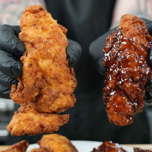 a person holding up a pair of chicken tenders
