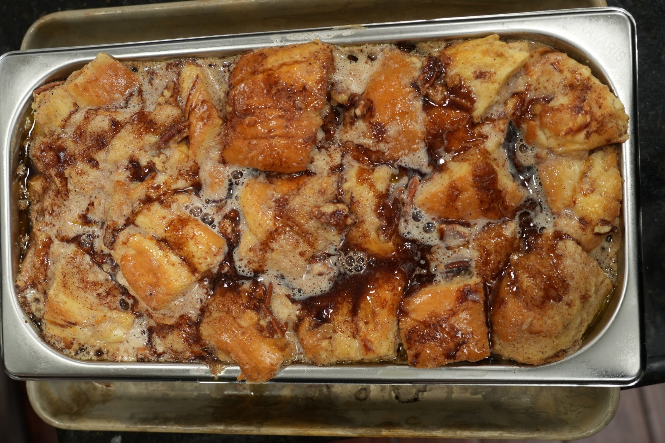 Close-up of warm cinnamon roll bread pudding with icing melting into the crevices
