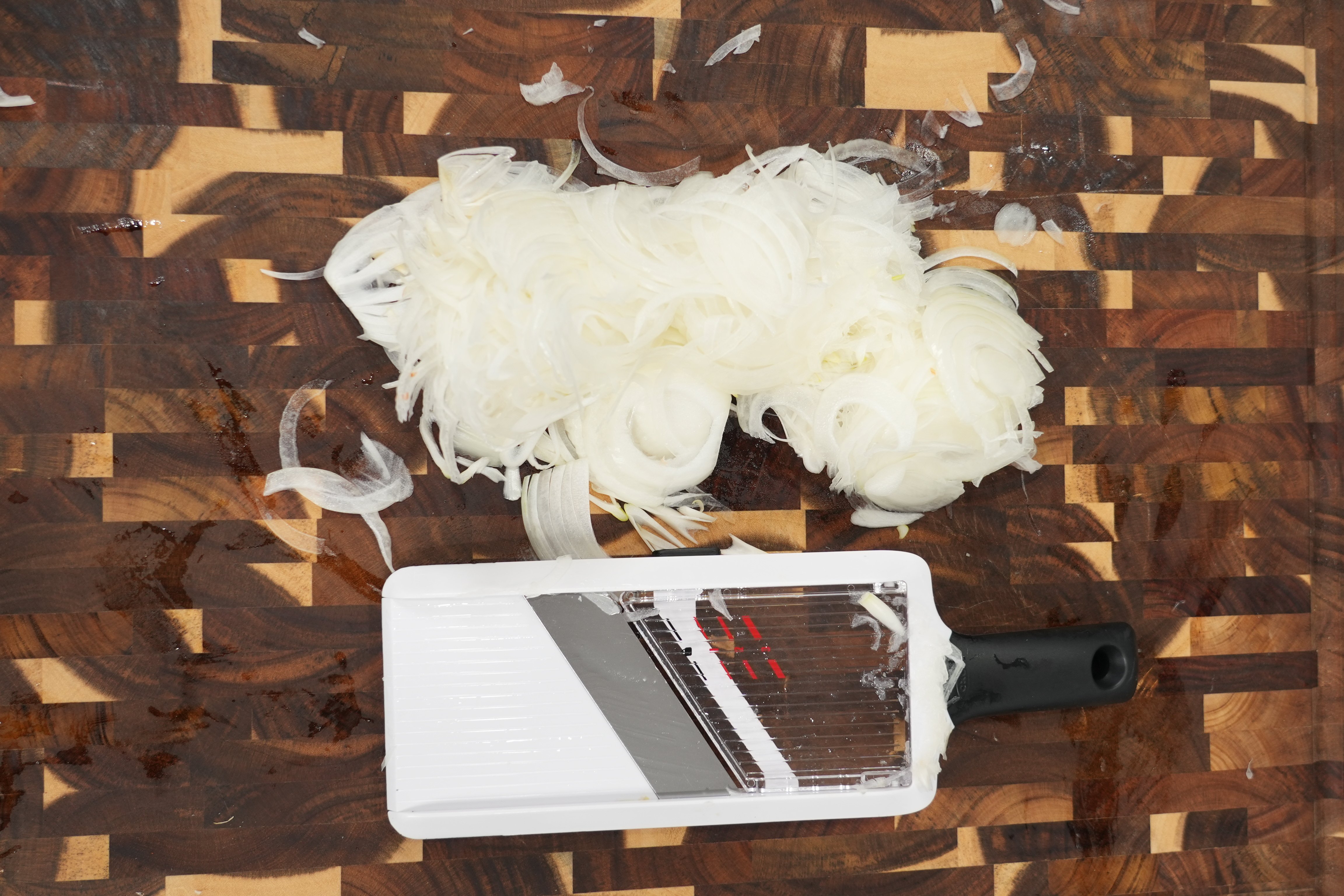 Thinly sliced onions caramelizing in a pan with brown sugar
