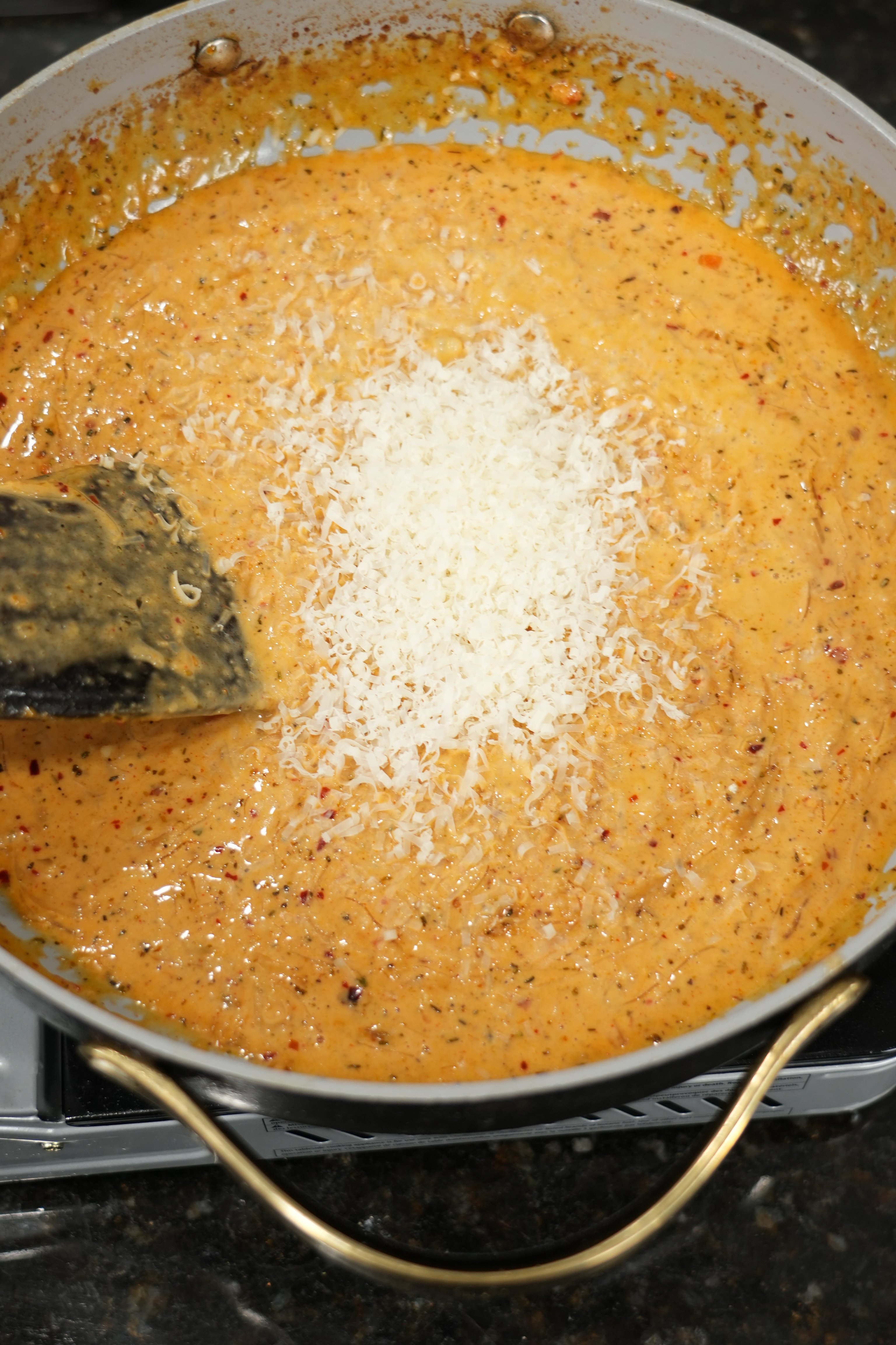 Creamy parmesan sauce coating spaghetti with caramelized onions