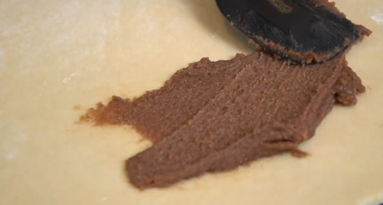 Rolling cinnamon roll dough into a log