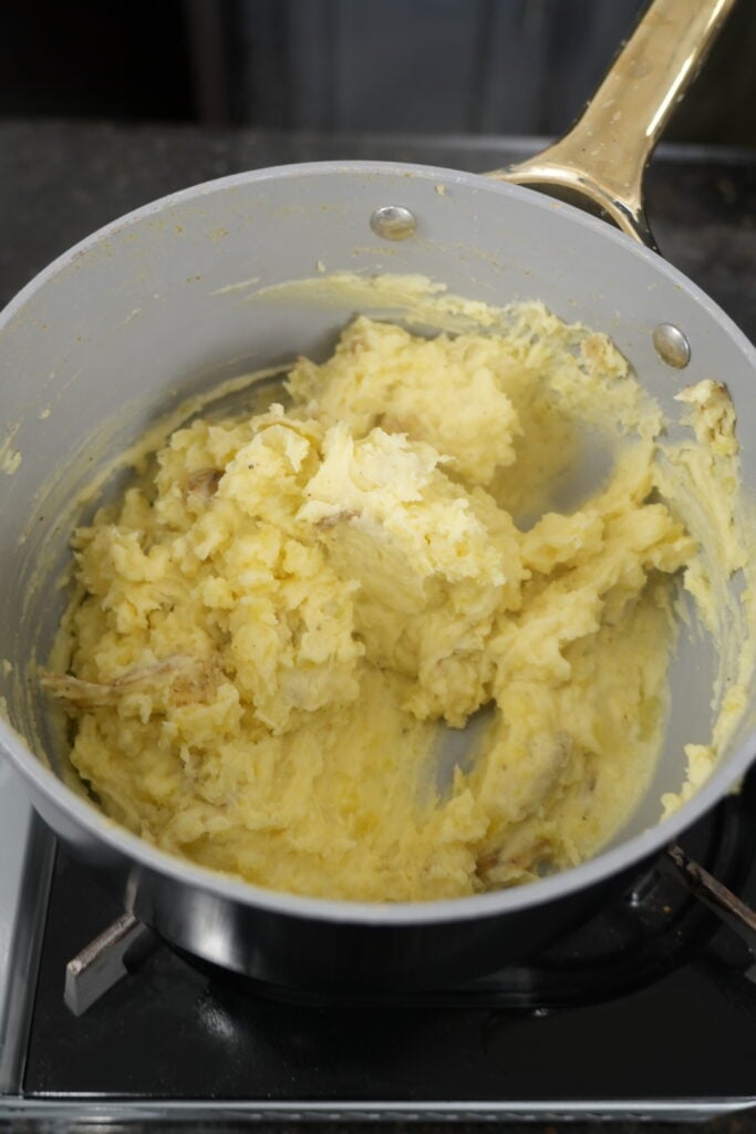 Cremini mushrooms saut&eacute;ing in butter until golden brown in a stainless pan