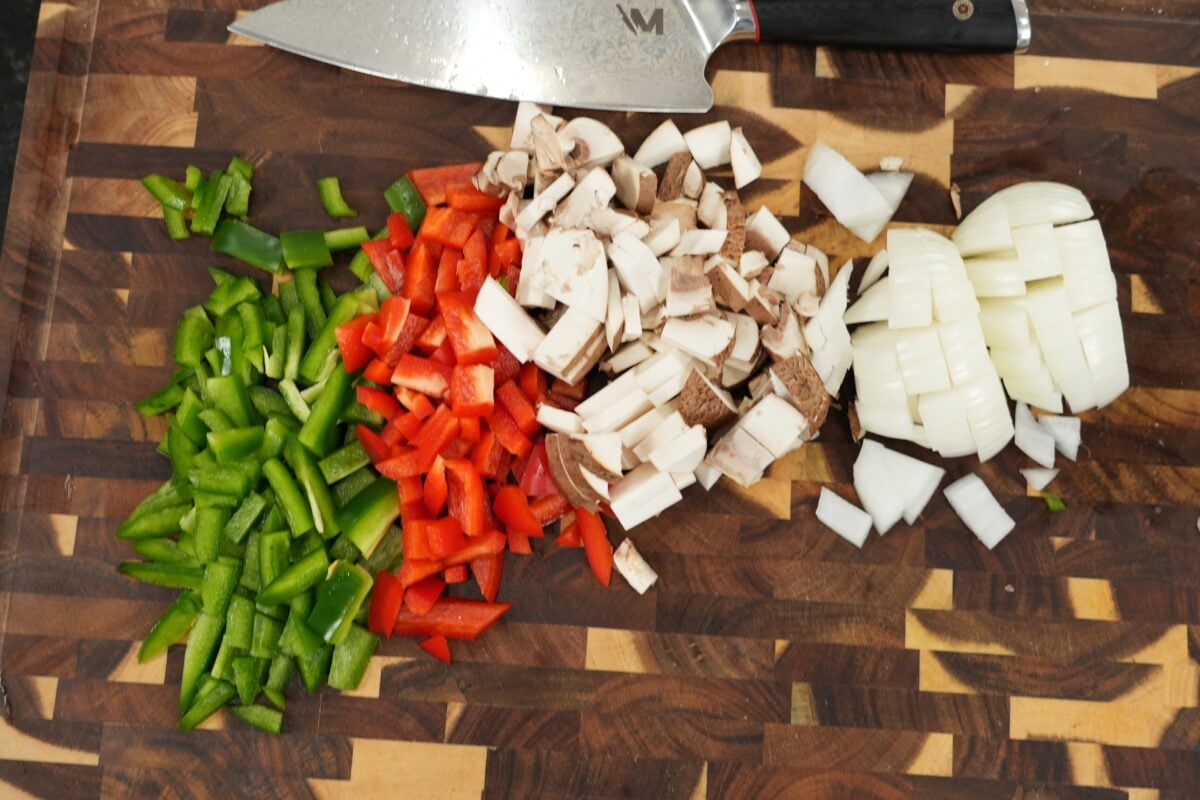 saut&eacute;ed bell peppers onions and mushrooms in a skillet