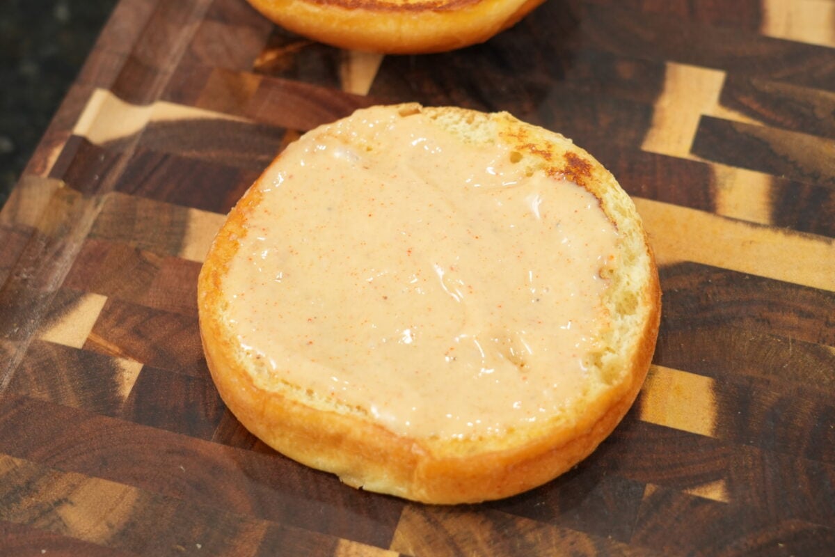 drizzling homemade hot honey over crispy fried chicken sandwich