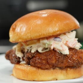 hot honey chicken sandwich with crispy fried chicken and coleslaw on a brioche bun