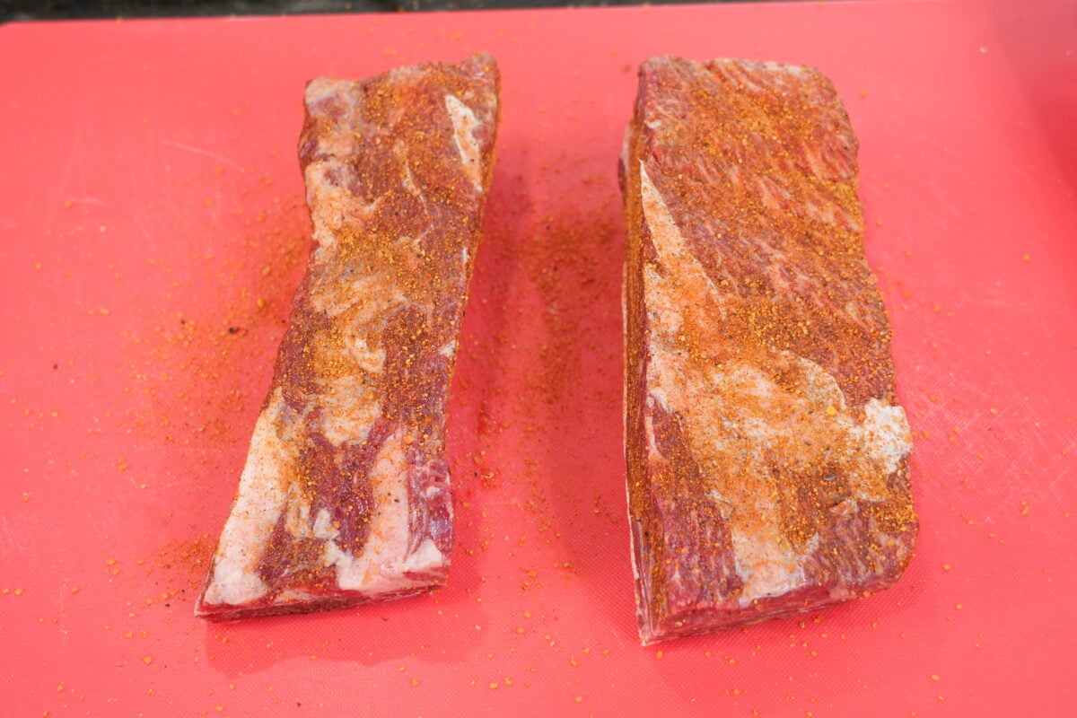 Seasoned beef ribs on a baking sheet ready for the oven