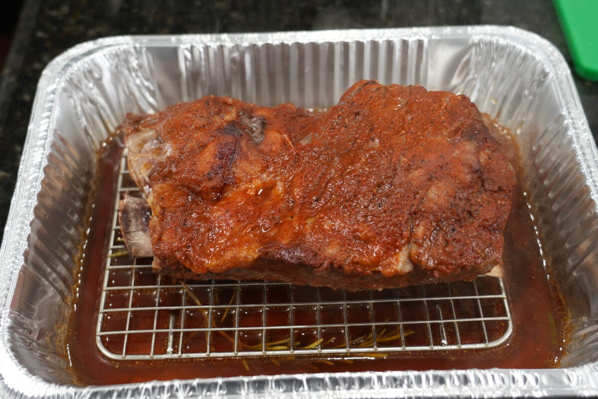 Bone-in ribs braising low and slow in aromatic liquid