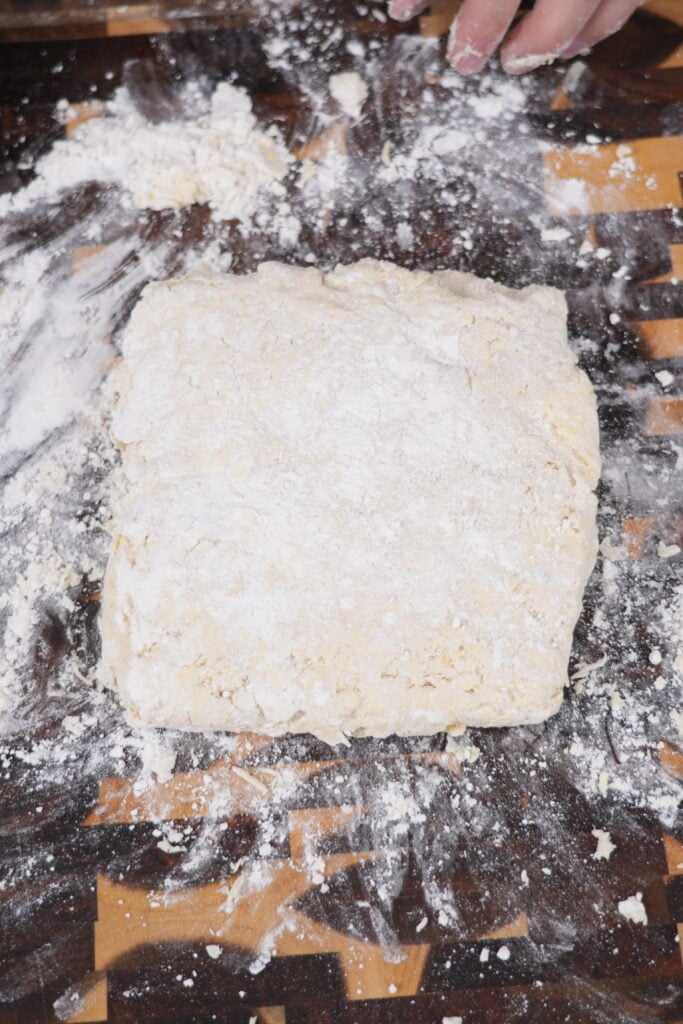 Pressing and folding the dough on a floured surface