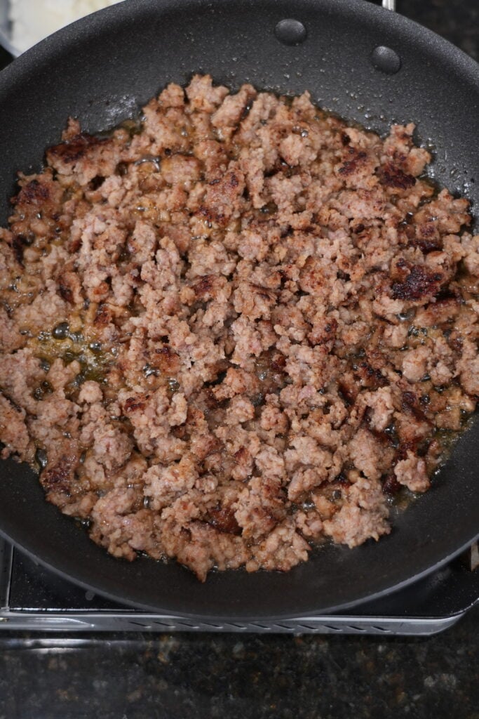 Browning crumbled meat and simmering a creamy peppered sauce in a cast-iron skillet