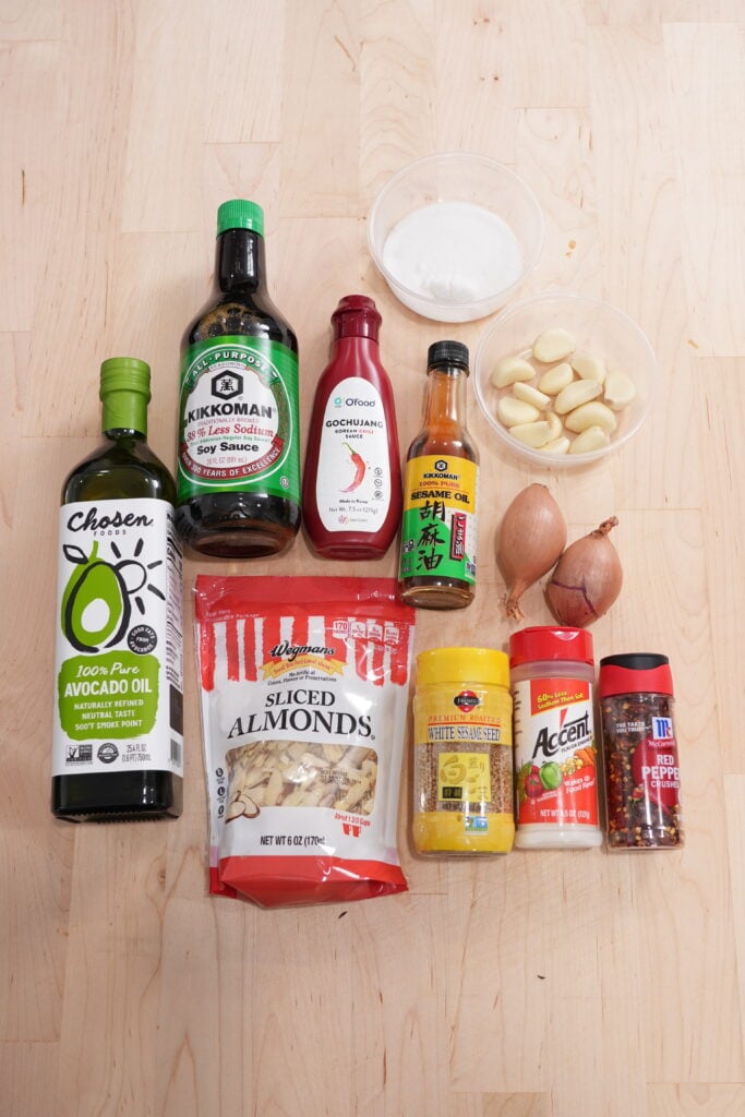 Ingredients for crispy chili oil: garlic, shallots, chili flakes, almonds, sesame seeds, and gochujang