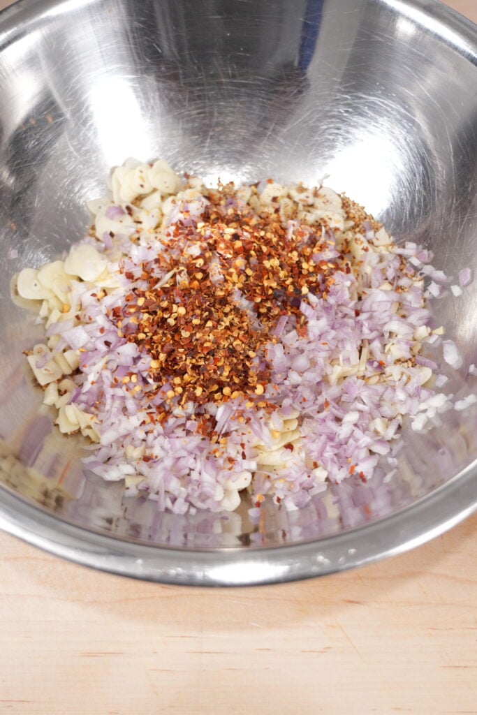 Pouring smoking-hot oil over the dry aromatics in a metal bowl