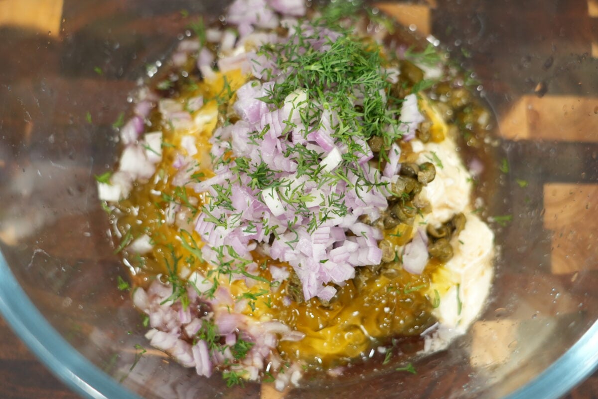 Whisking gourmet tartar sauce with capers, shallot, and dill