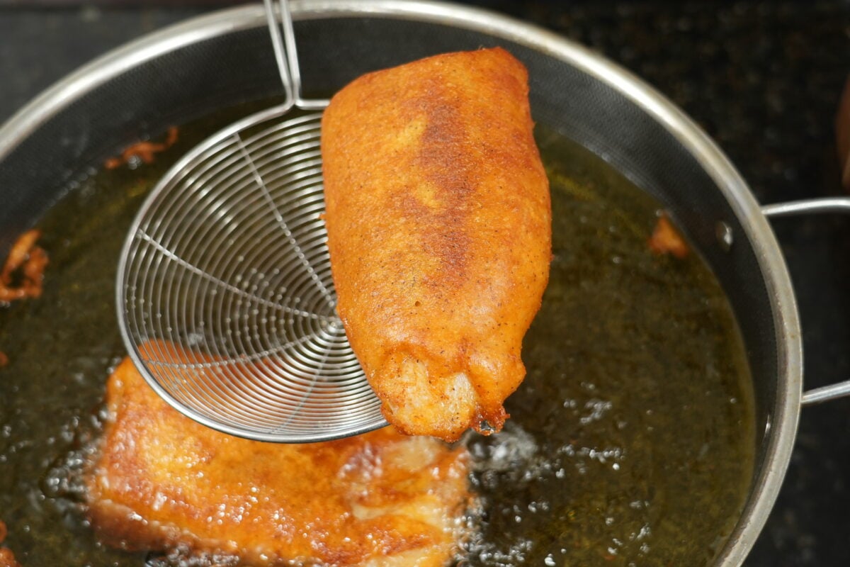 A battered fillet frying to golden and crisp in hot oil