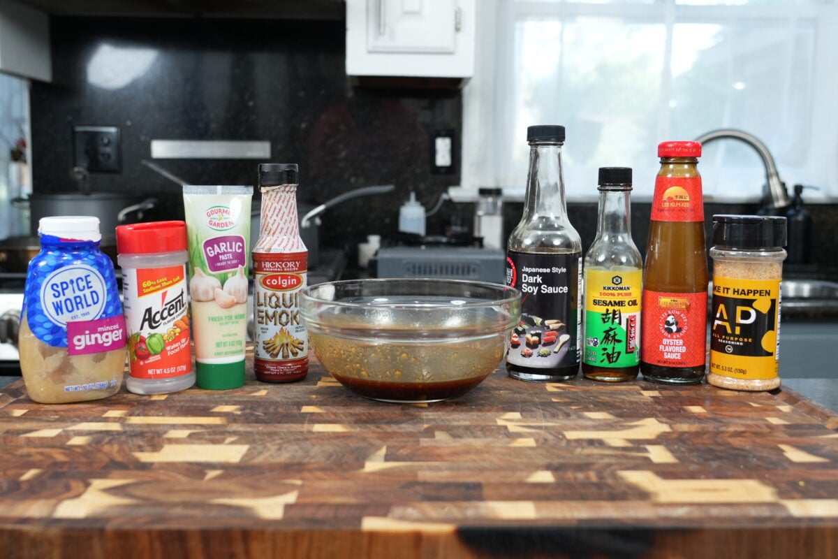 Dark soy sauce, oyster sauce, toasted sesame oil and AP Seasoning lined up on a kitchen counter