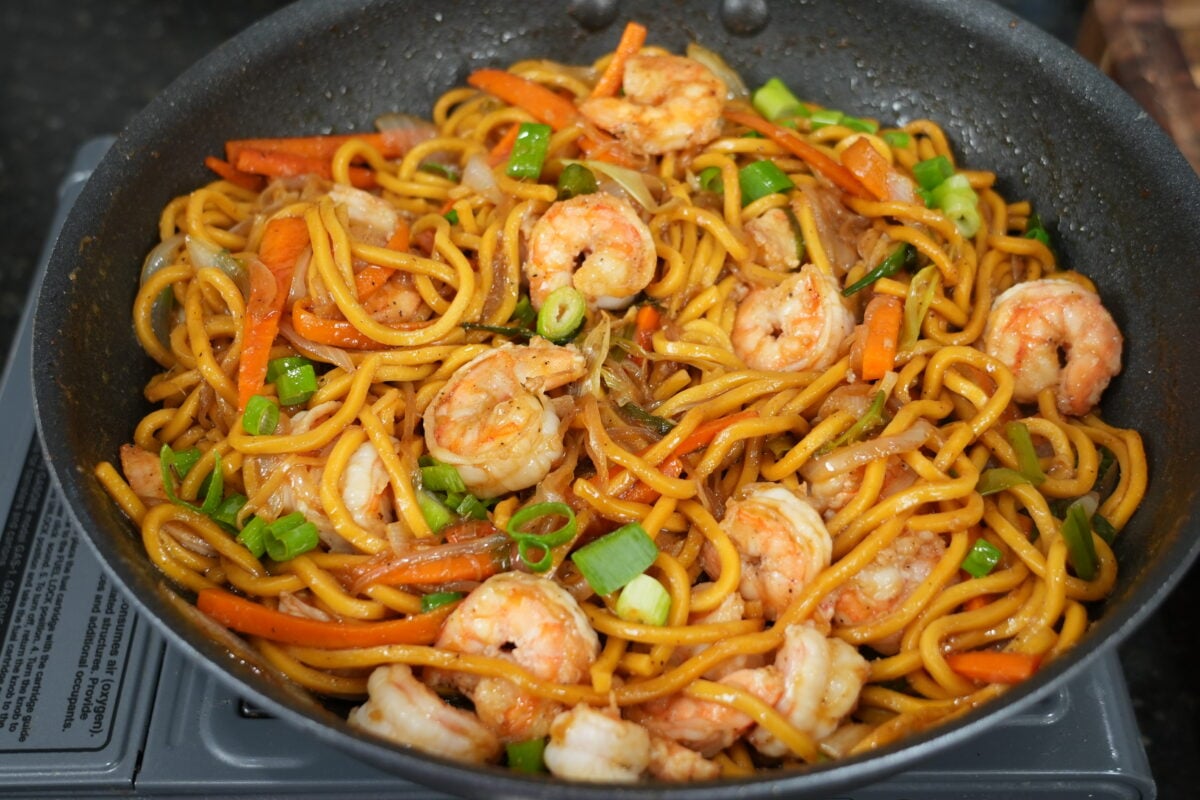 Shrimp lo mein tossed in the skillet with sauce coating every noodle