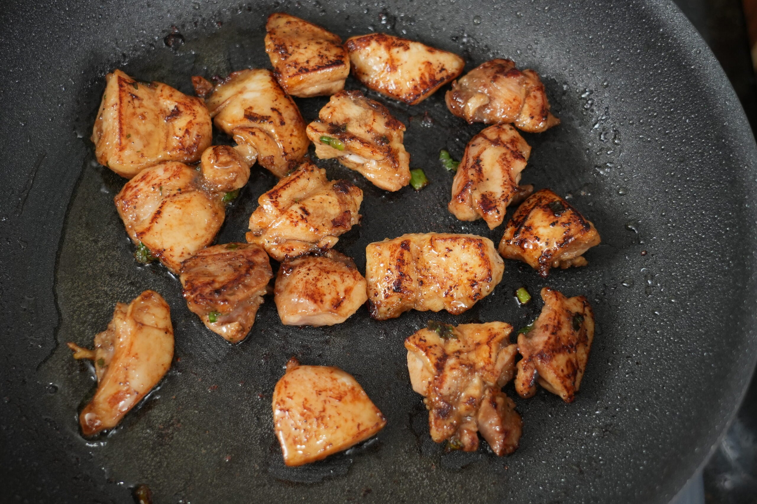 Chicken thighs browning in a skillet