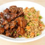 Mall-style bourbon chicken with egg fried rice on a white plate