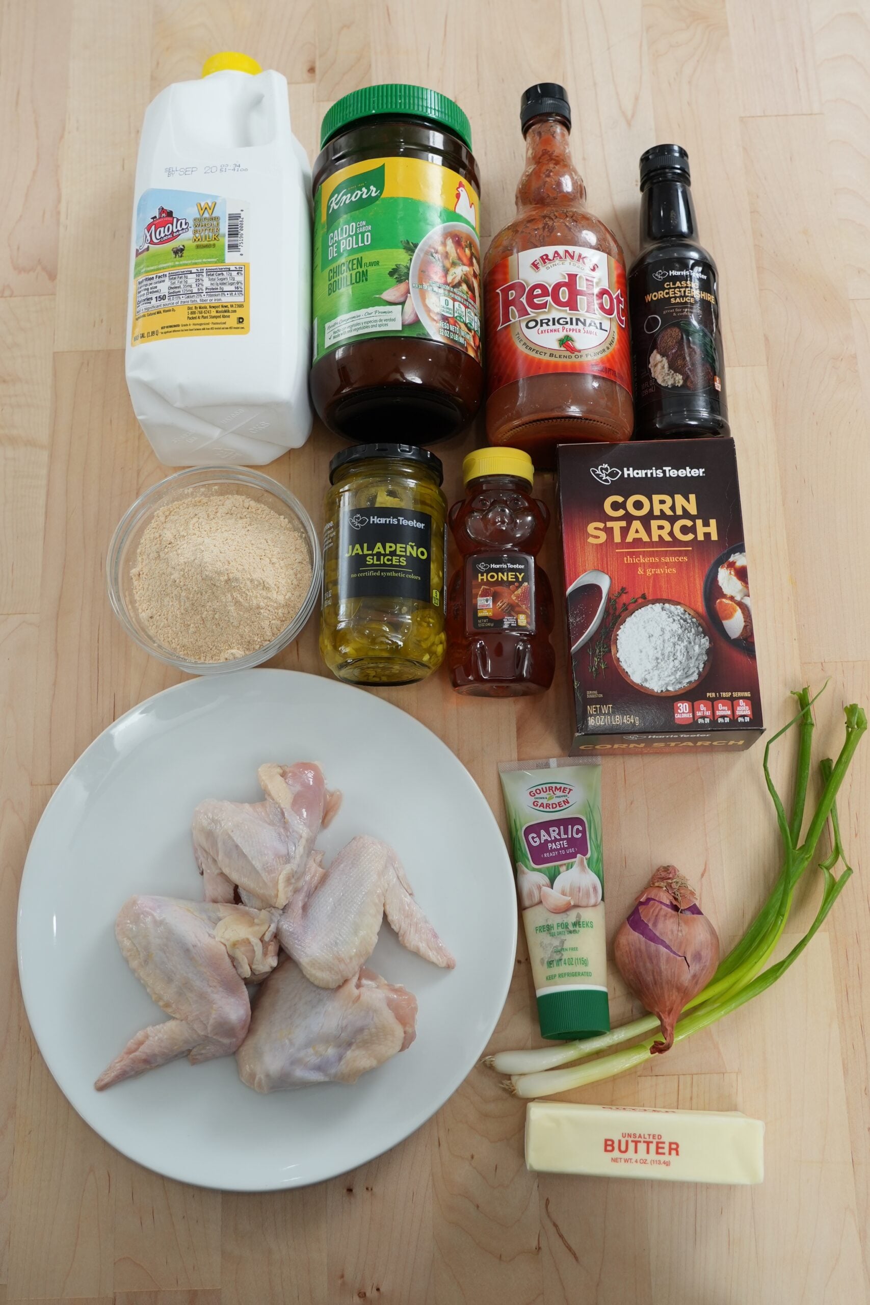 Ingredients for crispy fried chicken wings and jalapeño honey glaze arranged on a worktop