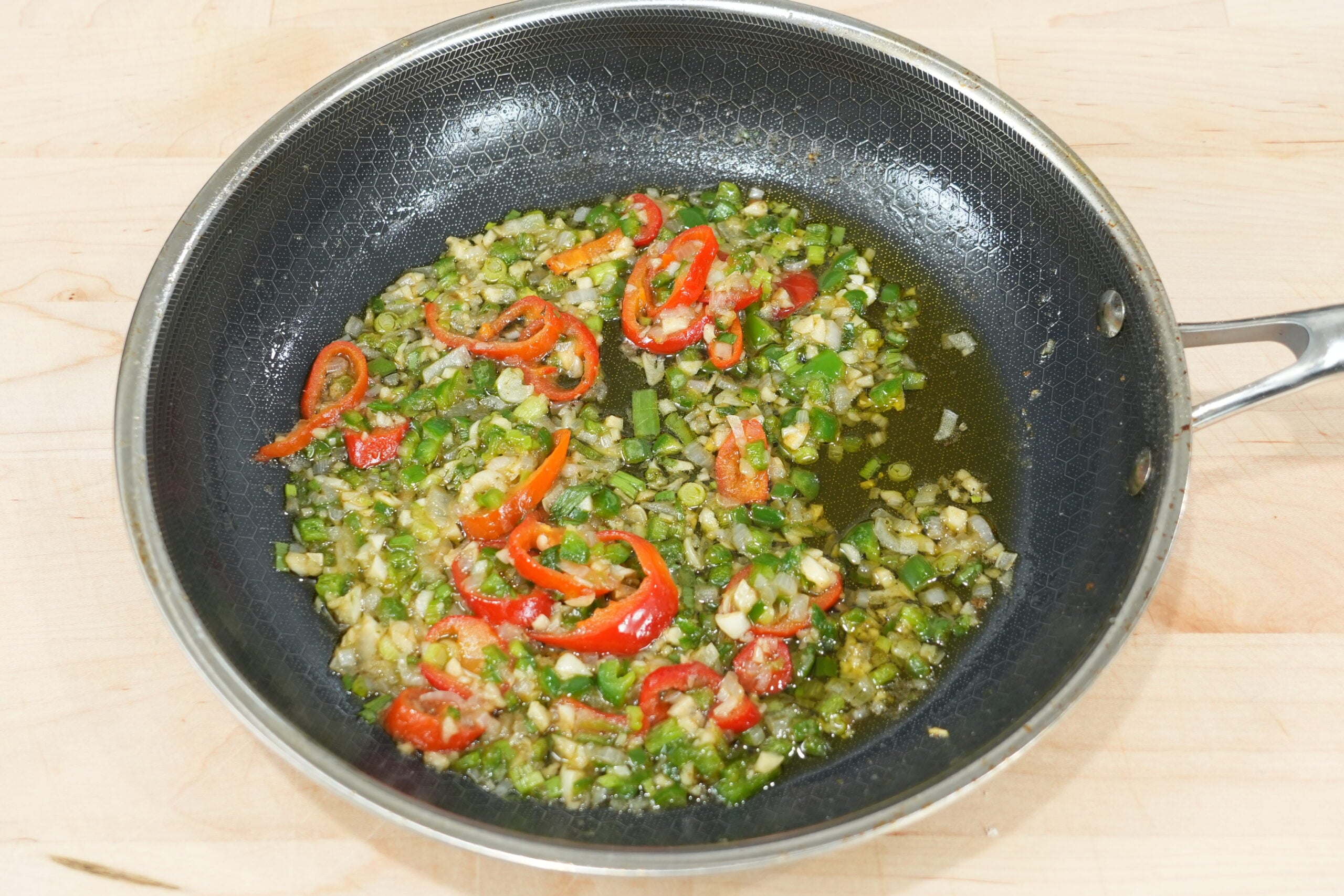Aromatics and butter cooking in a skillet for salt and pepper shrimp