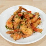 Crispy salt and pepper shrimp with garlic chili butter and lime on a plate