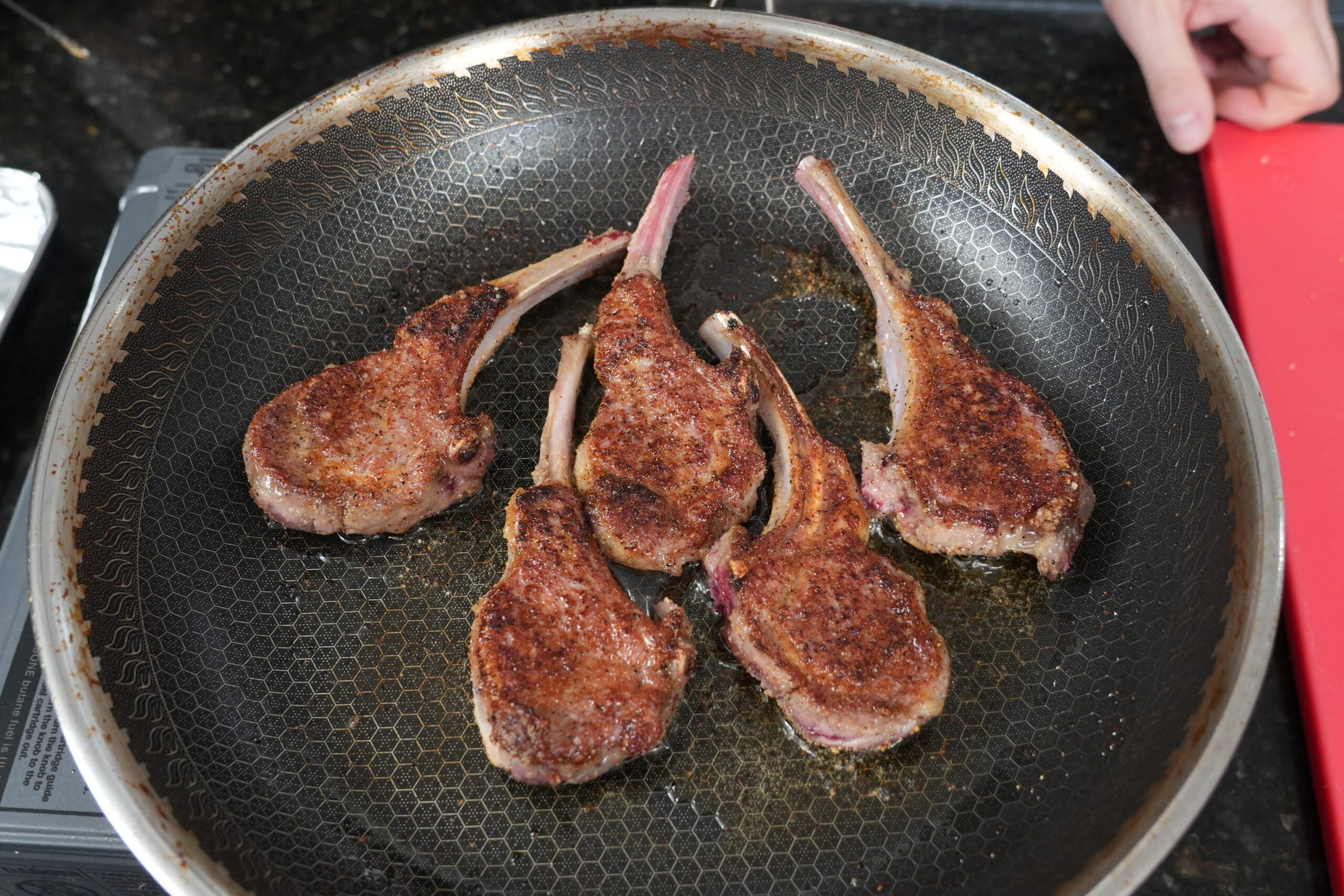 Lamb chops searing in a hot skillet