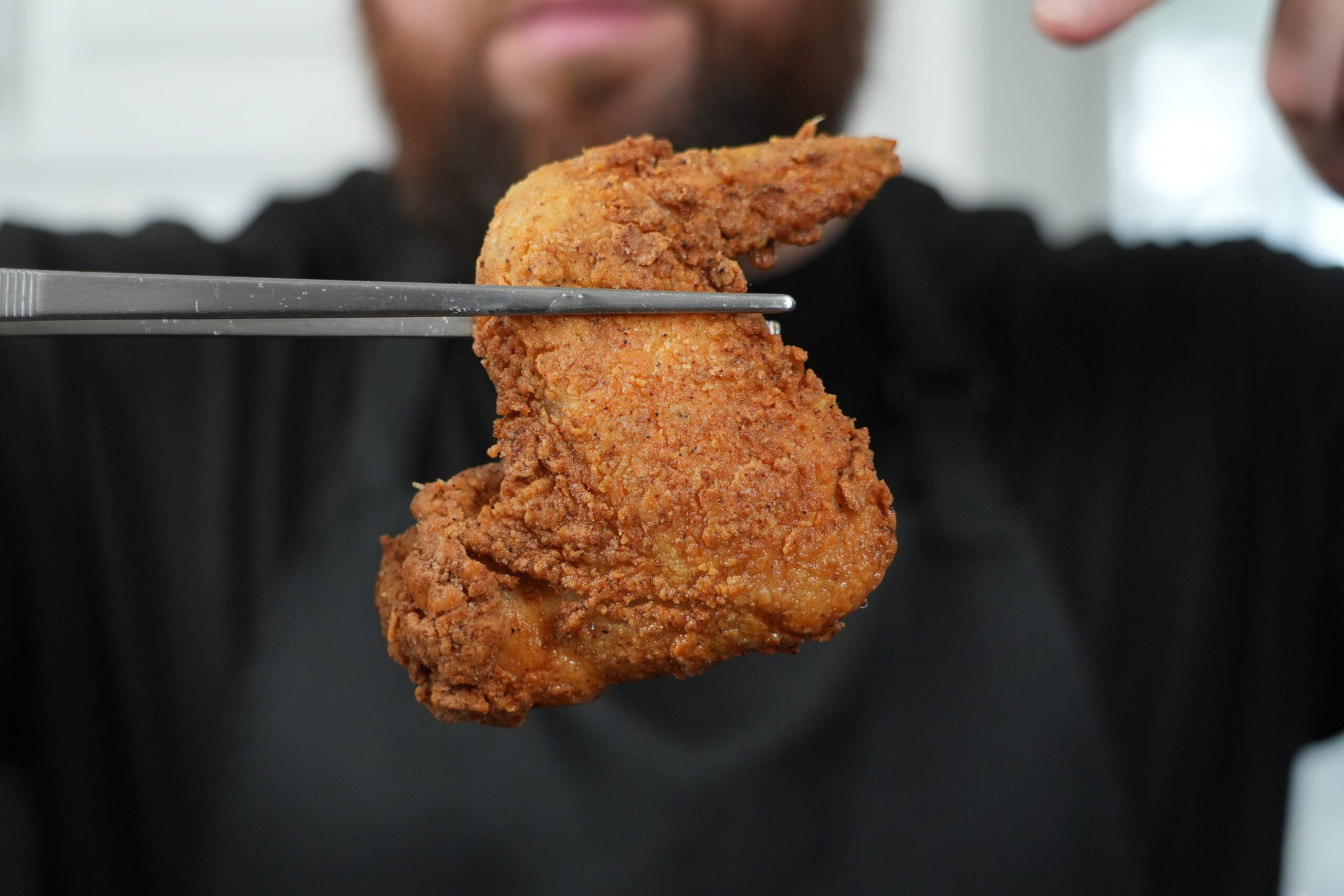 Crispy golden fried whole chicken wing just lifted from the oil