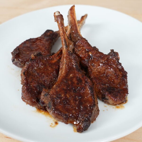 Sticky Asian glazed lamb chops plated with a glossy sauce