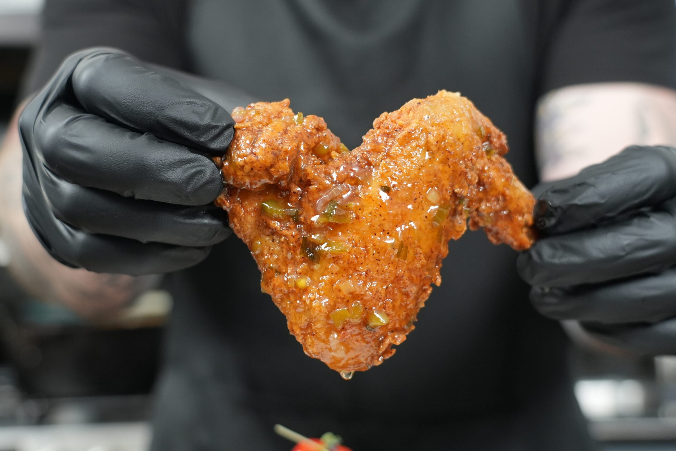 Close-up of a fried chicken wing glazed with jalapeño honey glaze