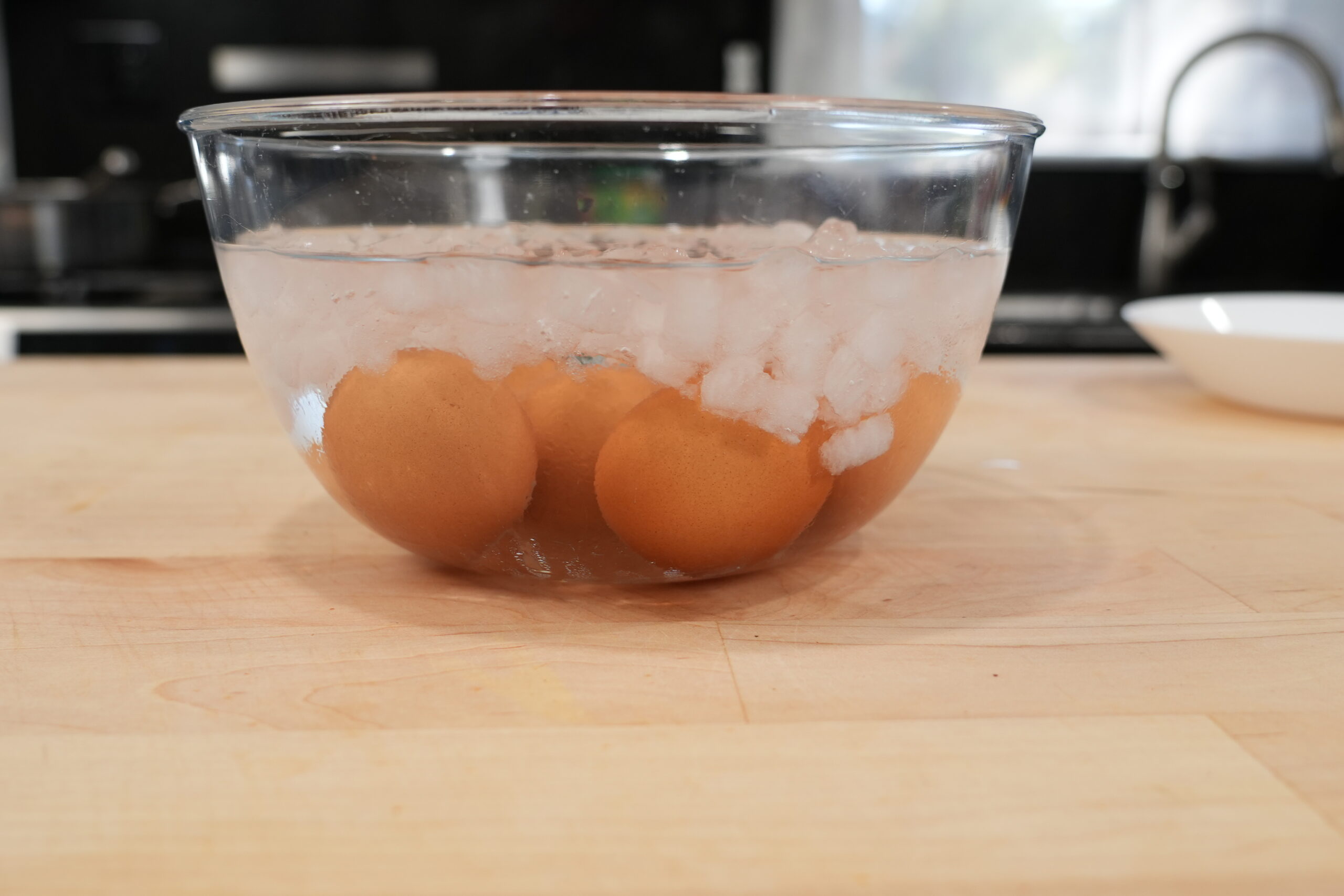 Hard-boiled eggs cooling in a bowl of ice water
