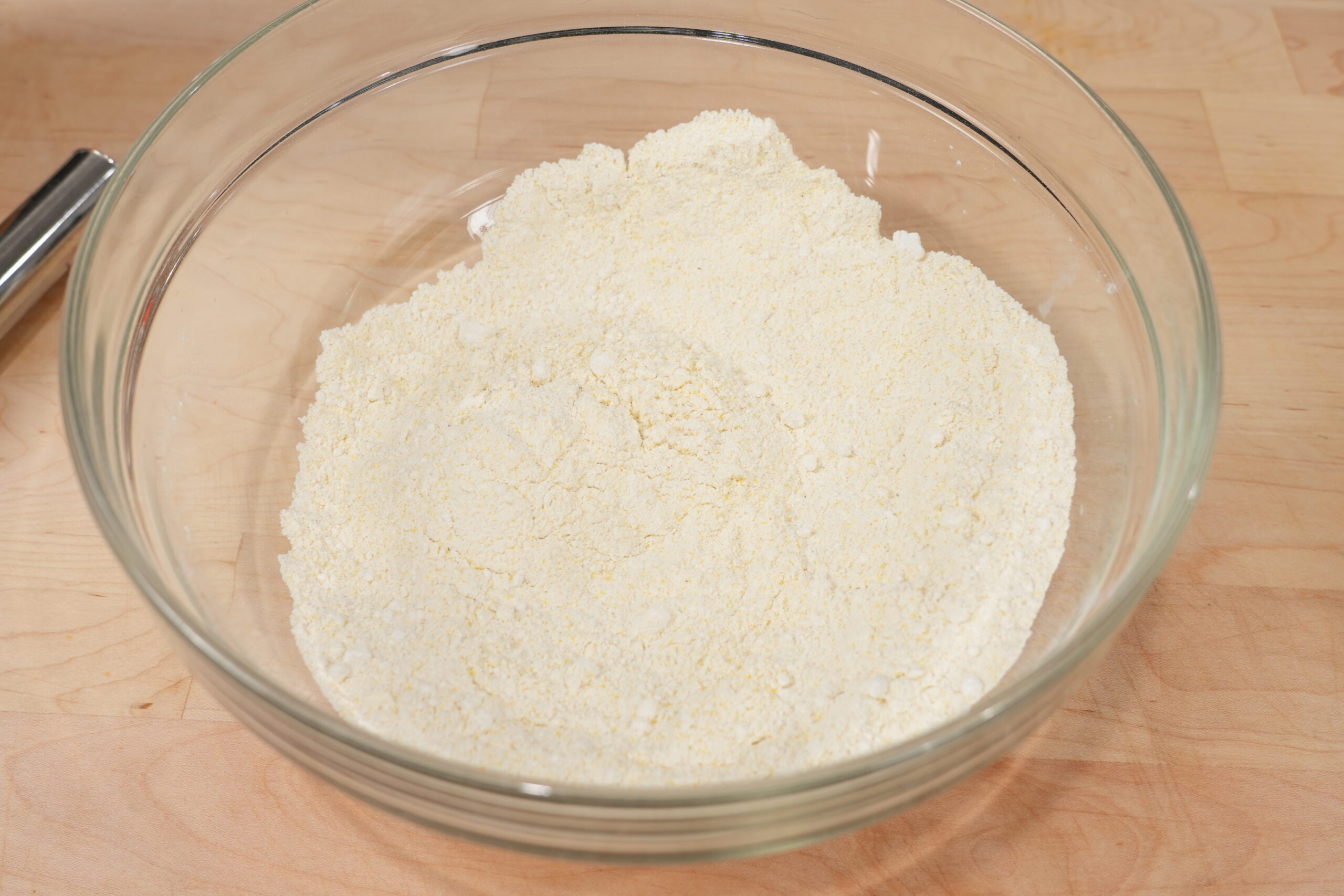 Cornmeal, flour, sugar, baking powder, and salt whisked together in a glass bowl