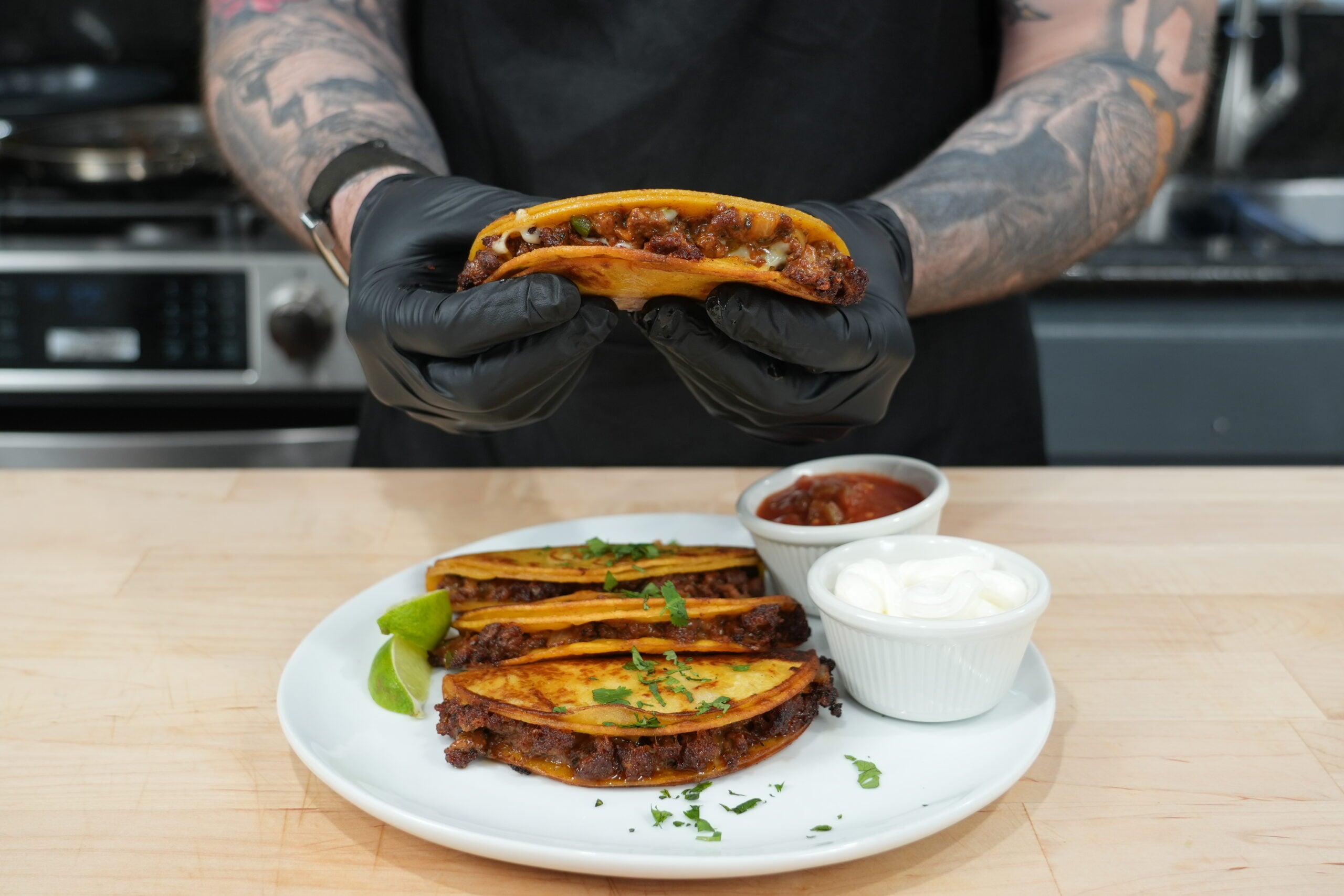 Crispy cheesy beef tacos with salsa and sour cream