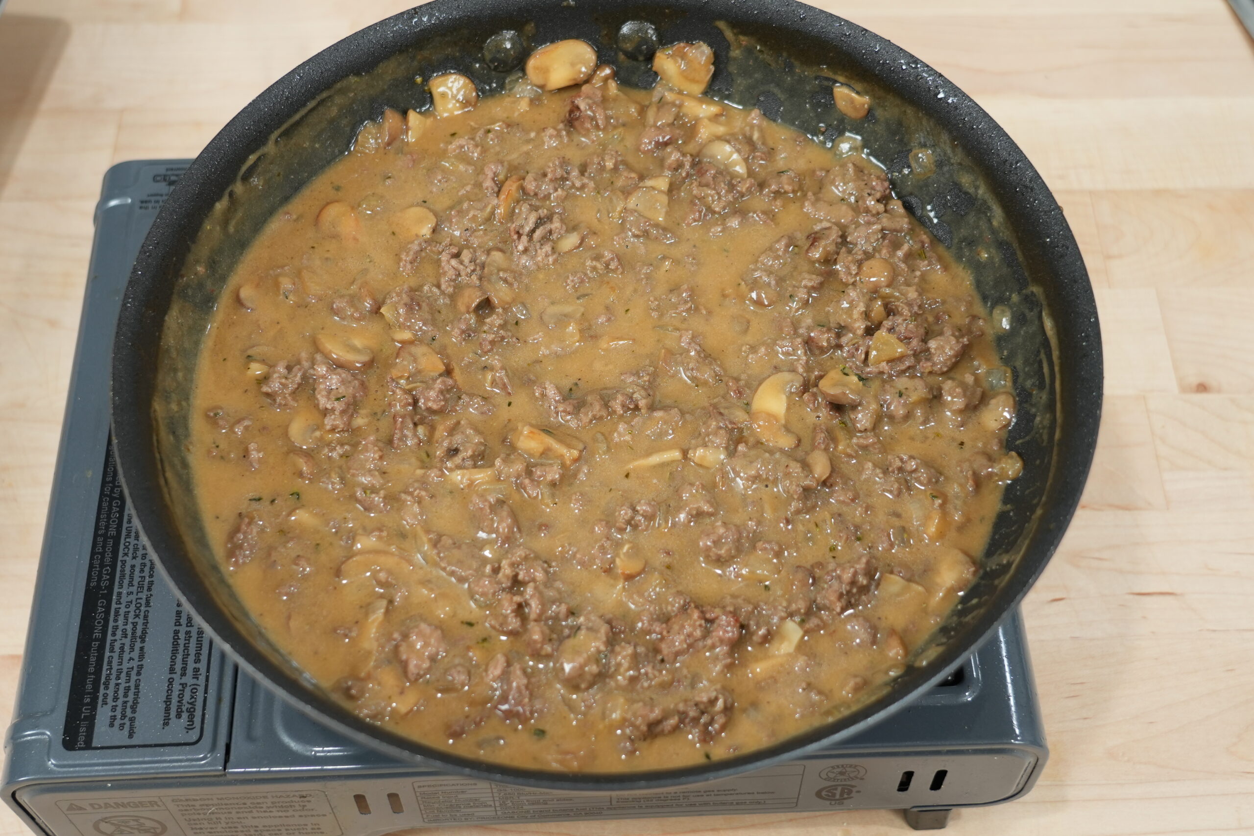 Creamy beef and mushroom stroganoff gravy simmering in a skillet