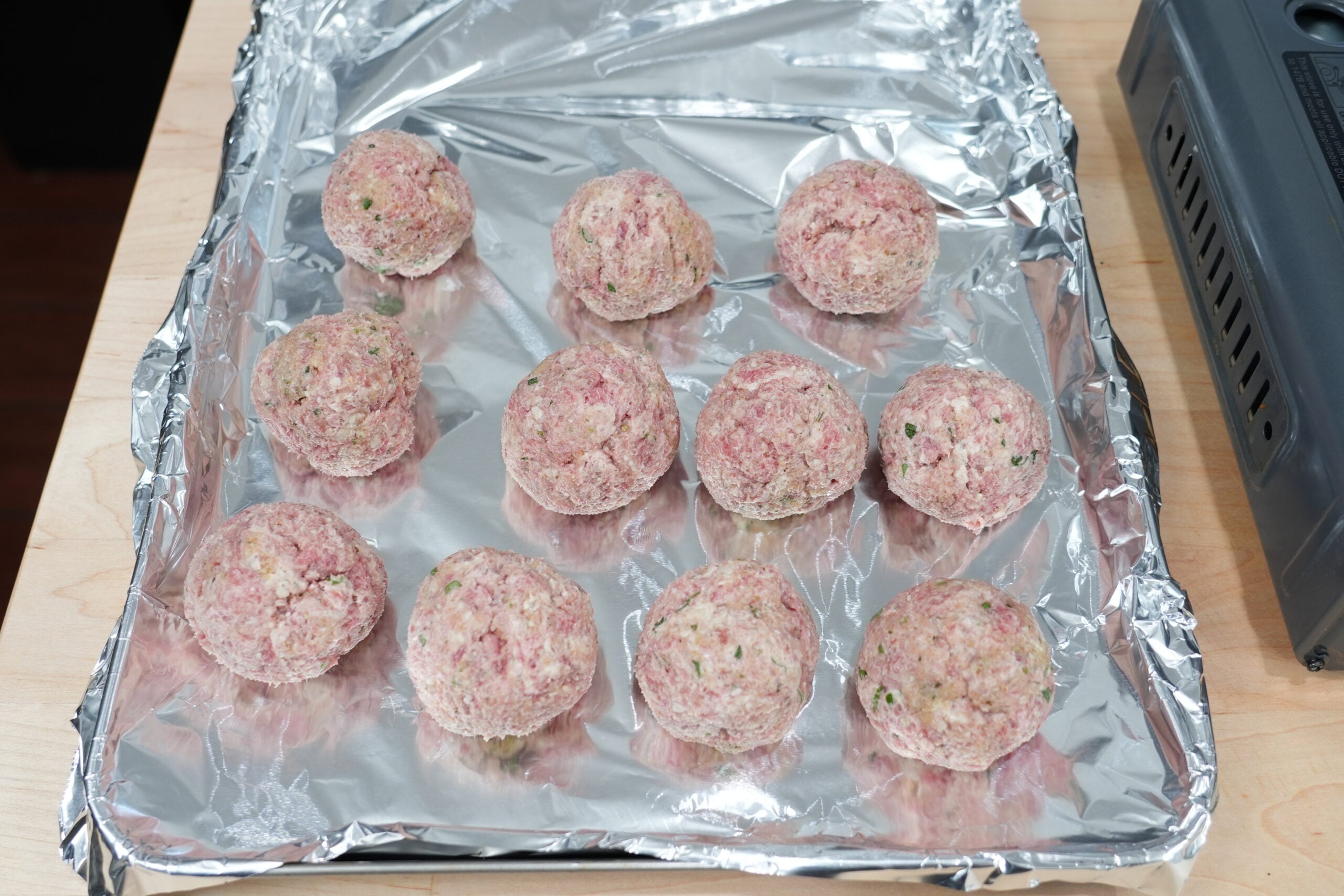 Two-ounce meatballs shaped and arranged on a baking sheet