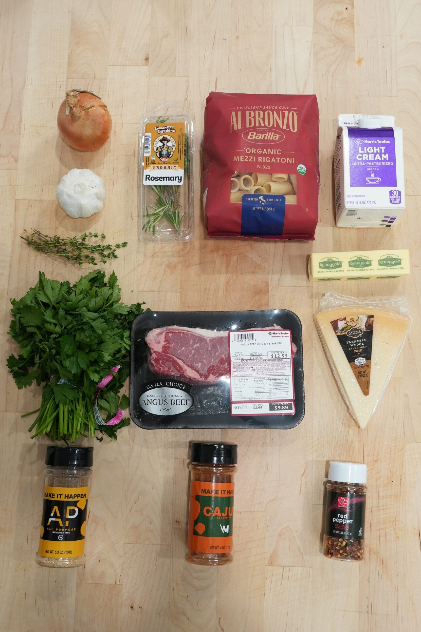 Ingredients for Cajun steak pasta including steak, rigatoni, cream, Parmesan and seasonings