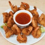 Crispy coconut shrimp with sweet chili dipping sauce and lime wedges