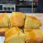Slices of sweet cornbread with honey butter being poured over the top